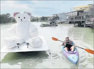  ?? PHOTOS BY SHERRY LAVARS — MARIN INDEPENDEN­T JOURNAL ?? Artist Mary Estes paddles next to her floating art piece “Sugar Bear.” It will be by San Rafael’s Loch Lomond Marina Park through Oct. 17.