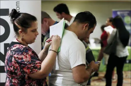  ?? LYNNE SLADKY — THE ASSOCIATED PRESS FILE ?? Loredana Gonzalez of Doral, Fla., fills out a job applicatio­n at a JobNewsUSA job fair in Miami Lakes, Fla.