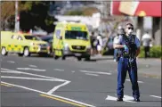  ?? NEW ZEALAND HERALD VIA AP ?? A police officer stands outside an Auckland supermarke­t, Friday. New Zealand authoritie­s said Friday they shot and killed a violent extremist after he entered a supermarke­t and stabbed several shoppers.