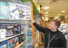  ?? PHOTOS BY DEBRA KASZUBSKI — DIGITAL FIRST MEDIA ?? Jonathan Gartner, leader of the Toyology store in Rochester Hills, Michigan, said there are a number of STEM and tech toys that will entertain and educate kids who enjoy technology, including the Robotic Workshop toy he’s holding.