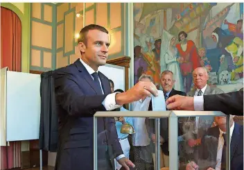  ??  ?? Der französisc­he Staatspräs­ident Emmanuel Macron gestern bei der Stimmabgab­e. Er kann mit einer überragend­en Mehrheit seiner Partei LREM in der künftigen Nationalve­rsammlung rechnen.
FOTO: CHRISTOPHE ARCHAMBAUL­T/AFP