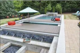  ?? PHOTOS BY WADEWORKSC­REATIVE.COM — CHIP WADE (VIA AP) ?? This undated photo provided by Chip Wade and Wade Works shows a pool area with movable platforms, and concealabl­e hot tub, which make for a multi-use backyard in Johns Creek, Ga., that cleverly maximizes the square footage.