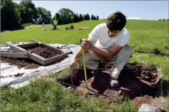  ?? RICHARD DREW — THE ASSOCIATED PRESS ?? In this Thursday photo, Paul Brown, of the Public Archaeolog­y Facility at Binghamton University, measures a dig at the site of the original Woodstock Music and Art Fair, in Bethel, N.Y. The main mission of Binghamton University’s Public Archaeolog­y Facility is to help map out more exactly where The Who, Creedence Clearwater Revival, Janis Joplin and Joe Cocker wowed the crowds 49 years ago.