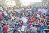  ?? REUTERS ?? People sit on tracks as they block train services during a protest demanding recruitmen­t into the railway in Mumbai on Tuesday. Agitators agreed to end the stir after negotiatio­ns with railway officials.