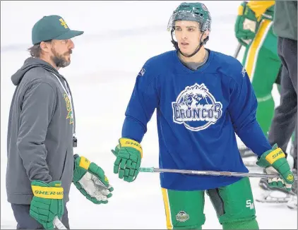  ?? CP PHOTO ?? Returning Humboldt Broncos player Brayden Camrud speaks with head coach Nathan Oystrick during a team practice Tuesday in Humboldt, Sask.