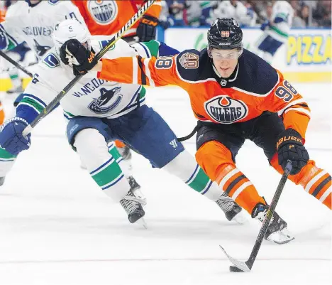  ?? THE CANADIAN PRESS ?? Vancouver’s Derrick Pouliot chases the Oilers’ Jesse Puljujarvi during second-period pre-season action in Edmonton on Tuesday.