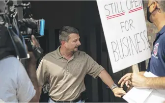  ?? ANTHONY VAZQUEZ/SUN-TIMES PHOTOS ?? John Kot, owner of All Steel Iron Works in Bedford Park, argues with protesters Tuesday who accused him of unjustly laying off workers to bust their union.