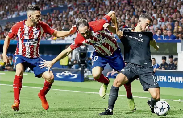  ??  ?? Getting shirty: Chelsea’s Eden Hazard (right) trying to ward off the challenge from Atletico Madrid’s Juanfran during their Champions League match on Wednesday. — AP