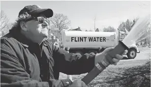  ?? STATE RUN FILMS/BRIARCLIFF ENTERTAINM­ENT ?? Michael Moore sprays “Flint water” at the Michigan State Capitol in Lansing in his documentar­y “Fahrenheit 11/9.” In the film, Moore tries to understand Trump’s rise to power.