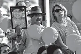  ?? GUSTAVO ANDRADE/AP ?? A man holds a portrait of a victim who died in the 2019 dam disaster last year in Brumadinho city, Minas Gerais state, Brazil. On Saturday, relatives of victims had a memorial.
