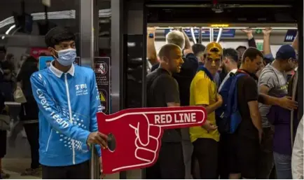  ?? MARTIN DIVISEK/EPA/MAXPPP ?? Un agent chargé de l’accueil des supporteur­s leur indique le chemin à suivre dans une station de métro de la capitale qatarienne.