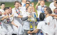  ?? REUTERS ?? Leeds United manager Marcelo Bielsa, centre, and his players celebrate with the Championsh­ip trophy at Elland Road this week.