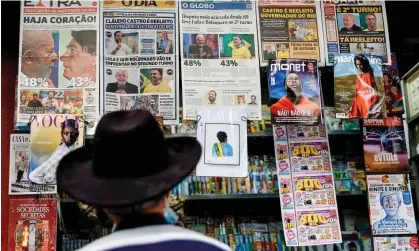  ?? Photograph: Buda Mendes/Getty Images ?? A man looks at Brazilian newspapers at a newsstand showing headlines a day after the general elections in Rio de Janeiro.
