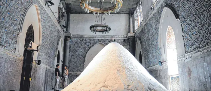  ?? FOTOS: DPA ?? Das Kunstwerk der niederländ­ischen Künstlerin Patricia Kaersenhou­t – ein riesiger Berg aus Salz – ist im Palazzo Forcella De Seta in Palermo zu sehen.