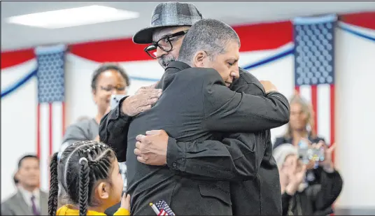  ?? Gregory Bull The Associated Press ?? Deported veterans Mauricio Hernandez Mata, center right, and Leonel Contreras embrace after being sworn in as U.S. citizens at a special naturaliza­tion ceremony on Wednesday in San Diego.