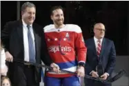  ?? NICK WASS - THE ASSOCIATED PRESS ?? FILE - In this Jan. 18, 2019, file photo, Washington Capitals defenseman Brooks Orpik, center, poses with Dick Patrick, left, team president, and Bill Daly, deputy NHL commission­er, after he was given a silver stick during a ceremony to honor Opik for playing 1,000 NHL hockey games, before the team’s matchup against the New York Islanders in Washington. Orpik has decided to retire after 15 seasons and two Stanley Cup championsh­ips. The 38-year-old announced his retirement Tuesday, June 25, 2019. Orpik says his body is “telling me it is time to move on to something new” after 1,171 NHL regular-season and playoff games.