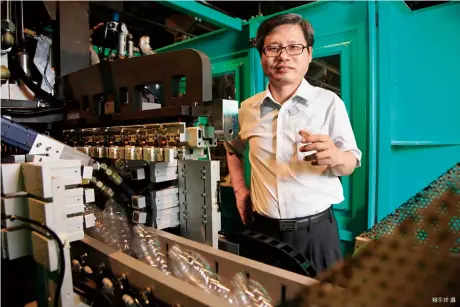  ?? 賴永祥攝 ?? 總經理謝樹林站在這台­由銓寶研發的「超高速直線式吹瓶機」旁，展示全球最快的實績。
