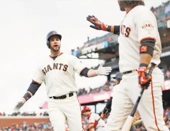  ?? Scott Strazzante / The Chronicle ?? Brandon Belt (left) celebrates a rarity for the Giants, a home run, with Brandon Crawford in the first inning against the Reds on May 11. The Giants are last in the major leagues in homers.