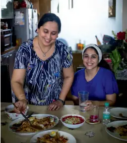  ??  ?? FROM ABOVE Parsi host Mahrukh Mogrelia and daughter Behnaz serving up the kesar chicken pulao; Mahrukh’s patra ni macchi – fish and homemade chutney cooked in a banana leaf.