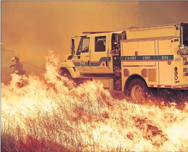  ?? PHOTOS BY NOAH BERGER — ASSOCIATED PRESS ?? A firefighte­r scrambles to stop the Pawnee Fire as it jumps across Highway 20 near Clearlake Oaks on Sunday.