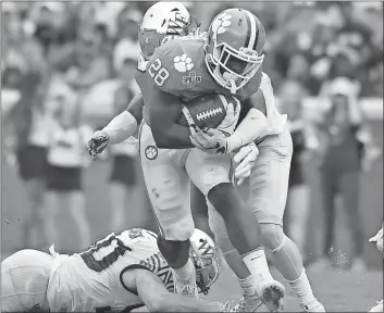  ?? Rainier Ehrhardt / The Associated Press ?? Clemson’s Tavien Feaster (center) pushes ahead for more yards during Saturday’s game against Wake Forest.