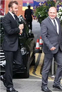  ??  ?? Paul Hughes, a former bodyguard of David Beckham, right, returns to the scene yesterday to pay tribute. On Saturday night, he tried to save Yousef’s life as the teenager lay dying in the street
