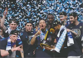  ?? The Associated Press ?? NATIONAL CHAMPIONS: Villanova players celebrate with the national championsh­ip trophy Monday night in San Antonio after beating Michigan, 79-62, in the NCAA Tournament title game.