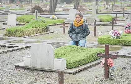  ??  ?? En la tumba. Laura Plasencia durante una visita a su padre en el cementerio de la Chacarita.