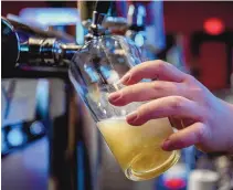  ?? EDDIE MOORE/ALBUQUERQU­E JOURNAL ?? The bartender at the Boxcar Restaurant in Santa Fe pours a Marble Double White ale on Feb. 10.