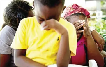  ?? BRENDAN SMIALOWSKI/AFP ?? Chrishon Dowkins (centre) and his grandmothe­r Catherine Russel (right) rest after arriving with other Hurricane Dorian survivors at the airport in Bahaman capital Nassau on Wednesday.