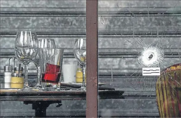  ?? DAVID RAMOS / GETTY ?? Impacto de bala en la cristalera del café Bonne Bière, en la calle de La Fontaine au Roi, uno de los escenarios de los atentados