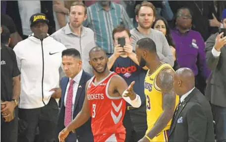  ?? Kevork Djansezian Getty Images ?? CHRIS PAUL (3) speaks with the Lakers’ LeBron James after Paul was ejected for fighting Saturday. Paul drew a two-game suspension.