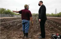  ?? Lisa Krantz / Staff photograph­er ?? Extension agent David Rodriguez, left, talks with Bexar County Commission­er Tommy Calvert during a planting ceremony at the new Greenies Urban Farm. Broccoli, cauliflowe­r, kale and cabbage were planted this week.