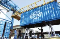  ??  ?? — Reuters Workers paint a shipping container at a container manufactur­ing company in Jiangsu province, China.