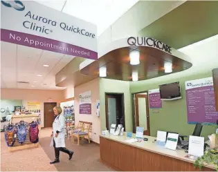  ?? MIKE DE SISTI / MILWAUKEE JOURNAL SENTINEL ?? Nurse practition­er Kelly Quandt walks to greet a patient at Aurora QuickCare Clinic in Mequon.