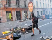  ??  ?? Manifestan­te en Barcelona con el rostro de Sánchez.
