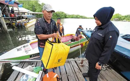  ?? — bernama ?? Special delivery: an election committee member delivering voting tools to a polling station in Pulau Libaran, Sandakan.