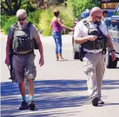  ??  ?? Federal law enforcemen­t officers scan the street looking for blood after a shooting near Christ Lutheran School on Thursday afternoon. One person was shot and was in stable condition, police said.