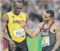  ?? TYLER ANDERSON ?? Silver medallist Andre De Grasse congratula­tes Usain Bolt, who took the gold, following the men’s 200-metre.