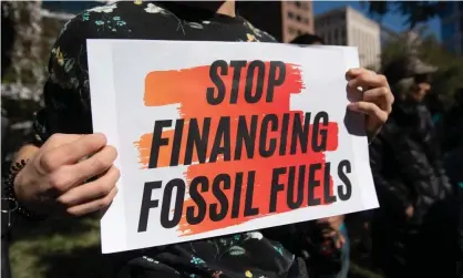  ??  ?? A sign protesting against investment­s in fossil fuels. The UN report says trillions of dollars of ‘perverse’ subsidies must be diverted to green energy. Photograph: Saul Loeb/AFP via Getty