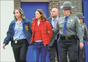  ?? Christian Abraham / Hearst Connecticu­t Media ?? Michelle Troconis is escorted to an awating police vehicle after being arrested and processed at State Police Troop G Headquarte­rs in Bridgeport on Tuesday.