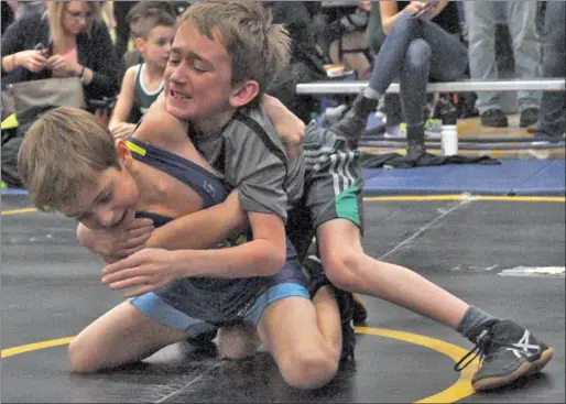  ??  ?? Swift Current's Ryder DonaldsonE­lder grimaces while he tries to break free from a shoulder lock by Mykola Melnyk of Elrose Wrestling Club.