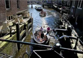  ?? PETER DEJONG — THE ASSOCIATED PRESS ?? People enjoy a boat ride on a sunny afternoon with temperatur­es going up to 27 degrees Celsius, or 80 degrees Fahrenheit, in Amsterdam, Netherland­s.