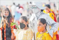  ?? Picture: REUTERS ?? People pose with a performanc­e artist at a beach amidst the spread of COVID-19 in Mumbai.