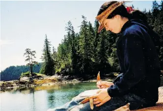  ?? NIKKI VAN SCHYNDEL ?? Nikki van Schyndel writing in her journal while in the Broughton Archipelag­o, a group of isolated islands near northern Vancouver Island which is the location for her new book.