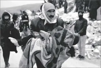  ?? AP PHOTO/GHAITH ALSAYED ?? A man carries the body of an earthquake victim in the Besnia village near the Turkish border, Idlib province, Syria, on Monday.