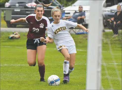  ?? Alex von Kleydorff / Hearst Connecticu­t Media ?? Weston’s Julia Rosenberg, right, brings the ball to the goal in Thursday’s game against Bethel. Rosenberg was one of six Trojans to score in the 7-0 rout of the Wildcats.