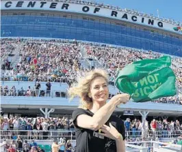  ?? SEAN GARDNER/GETTY IMAGES ?? Award-winning actress Charlize Theron waves the green flag to start Sunday’s 60th Daytona 500. Before the race, Theron said she couldn’t wait for “those cars to take off.”