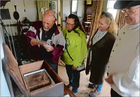  ?? DANA JENSEN/THE DAY ?? Michael Passmore, left, of Ballouvill­e, and his twin sister Michelle House of Dayville, both descendant­s of the Leffingwel­l, Bingham and Backus families of Norwich, and Sandy Kirca of Ballouvill­e look at the list of names that appear in the Leffingwel­l family Bible on Saturday while docent Dennis Guillemett­e, right, gives them a tour of the Leffingwel­l House during the Founders’ Day celebratio­n in Norwich.