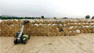  ?? Niu Lu/Xinhua ?? » NOVOS TEMPOS Máquina agrícola empilha fardos de palha de trigo na cidade chinesa de Bengbu, que fica na província de Anhui; reciclagem da palha ganha força no país